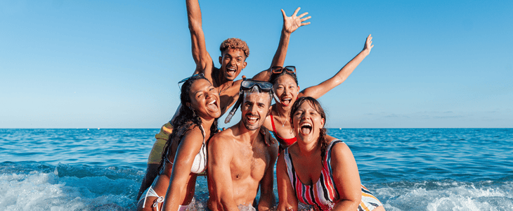 group of friends smiling at the beach